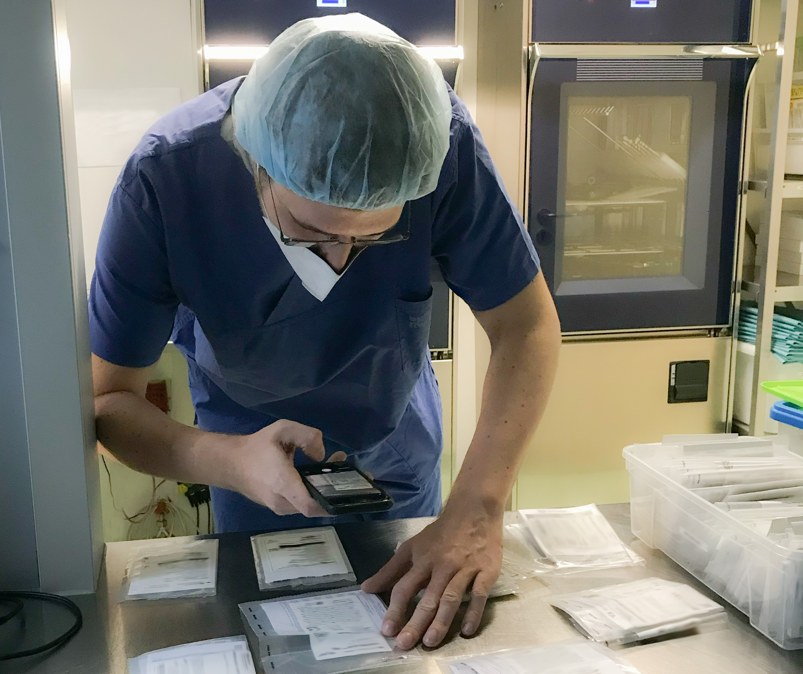 Mitarbeiter scannt Sterilgut mit dem Smartphone im OP-Zentrum